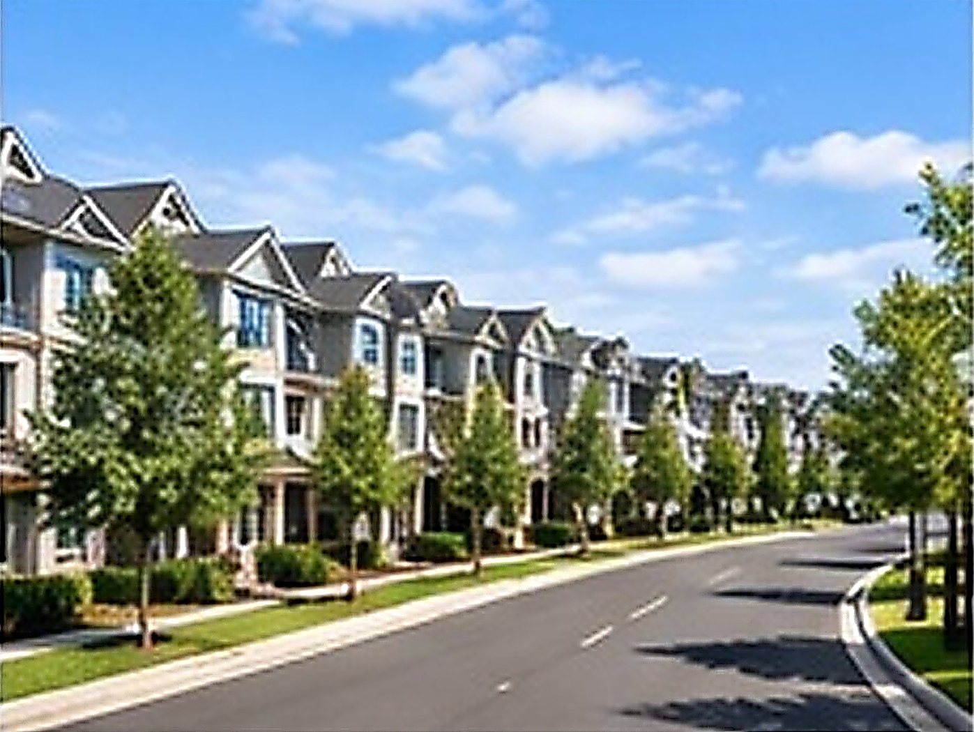 Row of townhomes along a tree-lined street