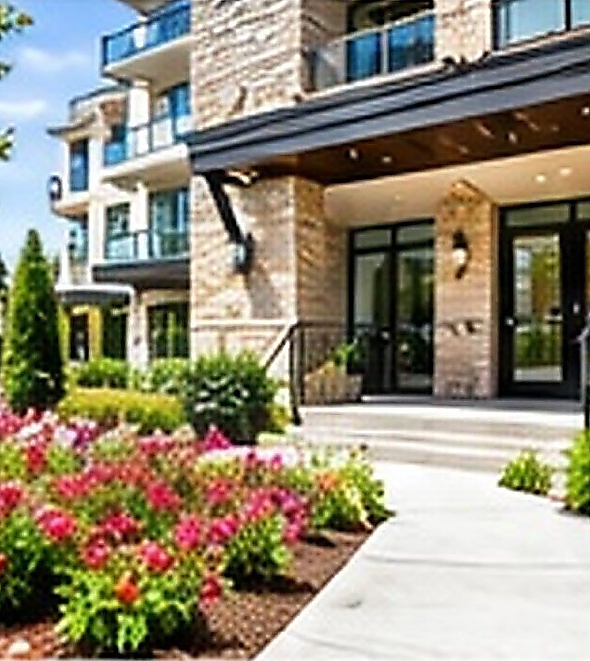 Manicured lawns and flowers along a building walkway